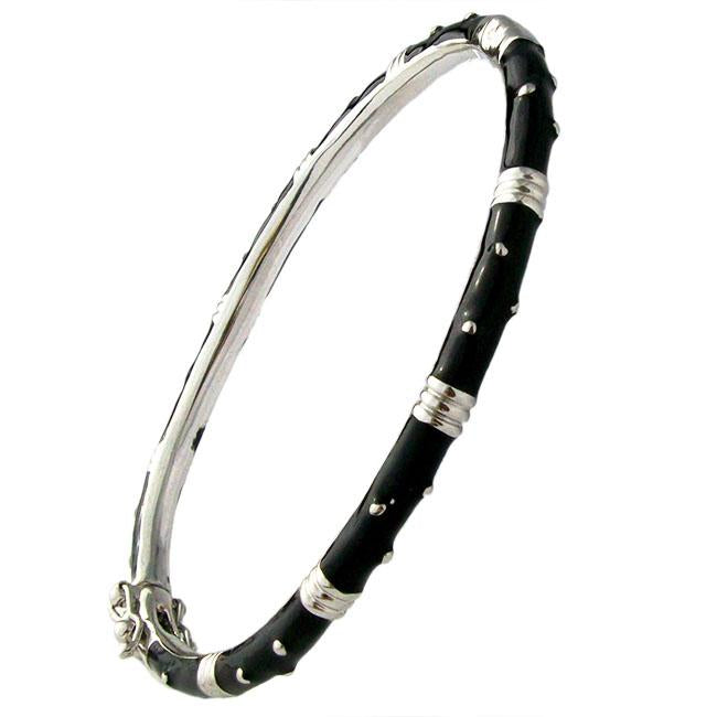 The zirconmania Bracelet Thin Gold tone Enamel Bangle 501B5339 features a slender, bamboo-inspired design with gold and black enamel segments and metallic accents wrapping around the bracelet.