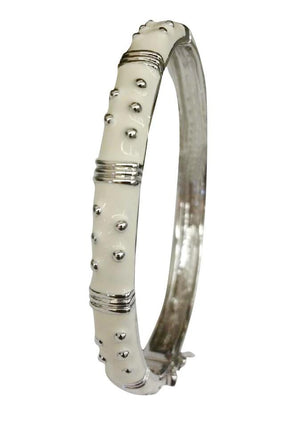 The zirconmania Bracelet Hinged Enamel Bangle 501B41902 is a silver bracelet with white enamel sections, silver studs, and wire accents. This hinged bangle includes a safety catch for extra security and stylish appeal.