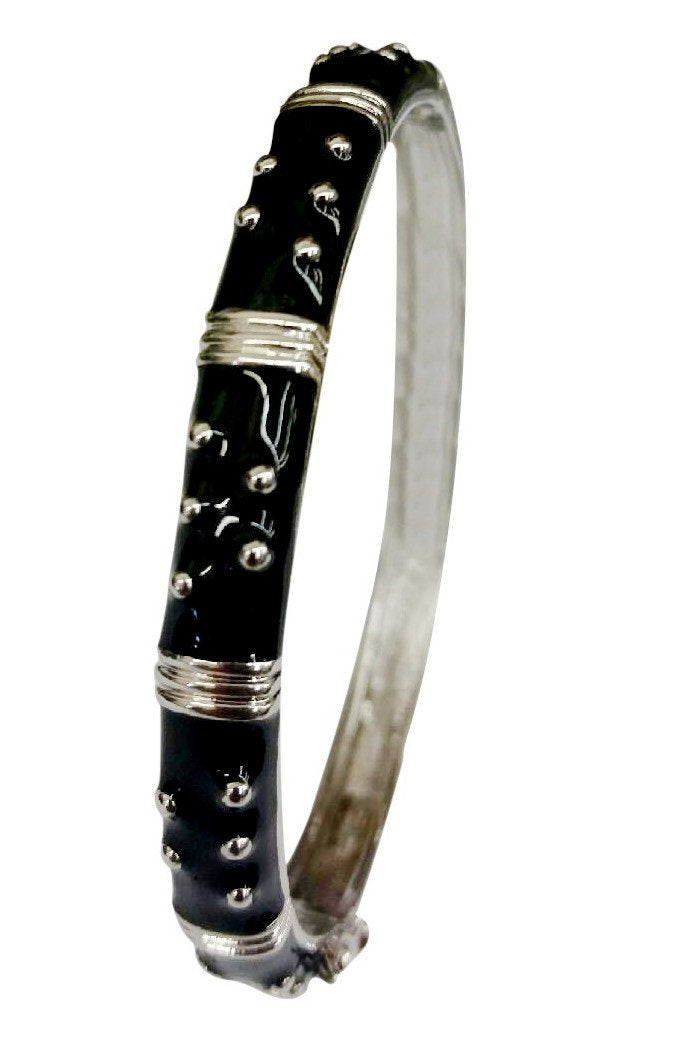 The zirconmania Bracelet Hinged Enamel Bangle 501B41902 features shiny black enamel sections, raised silver dot accents, wrapped silver wire details, and a secure safety catch.