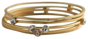 The zirconmania Bracelets Gold Stack-able .622B0102 features multiple overlapping gold bands with small, round clear gemstones set at intervals along the design.