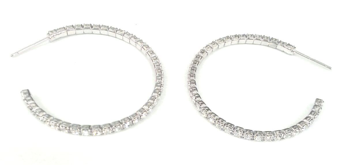 The zirconmania Earrings 2 mm Electroplated Feather Weight Hoop (.637E14302) feature a row of clear, sparkling gemstones along the outer edge and are displayed on a white background.
