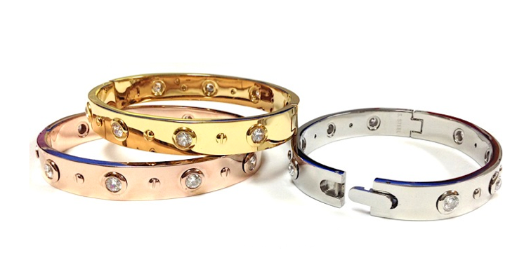 The zirconmania 655B1045 is a wide, high-polished, hinged stainless steel bangle featuring sparkling gemstones.