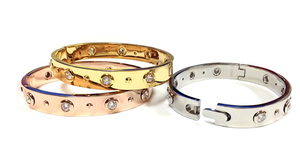 The zirconmania 655B1045 is a wide, high-polished, hinged stainless steel bangle featuring sparkling gemstones.
