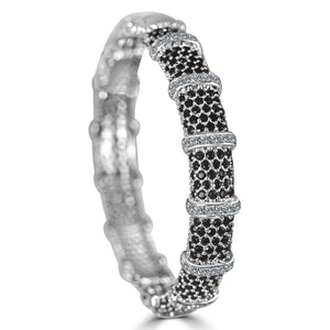 The zirconmania Bracelet Face-off line Stations wide fine Cubic Zirconia Set Hinged Bangle 698B100 features rows of small black stones and multiple bands of clear gems for a bold, patterned luxury look.