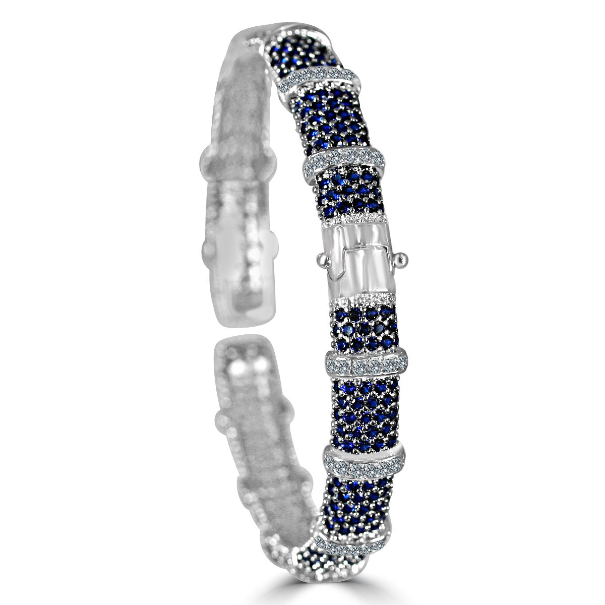 The zirconmania Bracelet Face-off line Stations wide fine Cubic Zirconia Set Hinged Bangle 698B100 features silver with rows of blue gemstones, clear diamonds, and a central rectangular cluster of sparkling zirconite stones. Shown on white background.