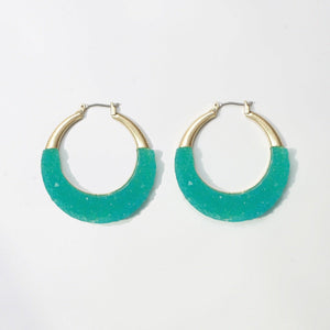 The zirconmania Textured Satin Bezel Alloy Setting Hoop Earring 661E581 features a hinged saddle closure, gold-tone metal at the top, and textured turquoise material on the lower half, shown against a white background.