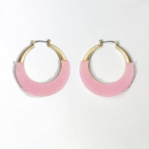The zirconmania Textured Satin Bezel Alloy Setting Hoop Earrings (661E581) feature gold-tone tops and light pink, textured curved bottoms with hinged saddle closure posts, shown on a plain white background.